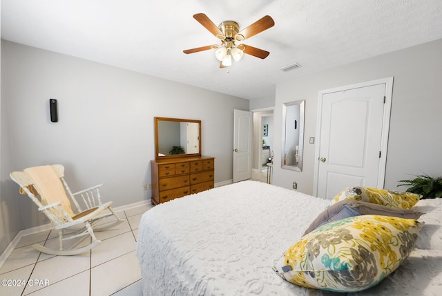 tiled bedroom featuring a textured ceiling and ceiling fan