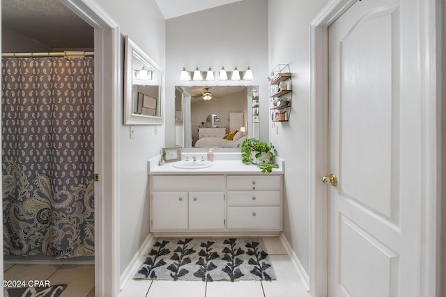 bathroom featuring tile patterned flooring, ceiling fan, lofted ceiling, and vanity