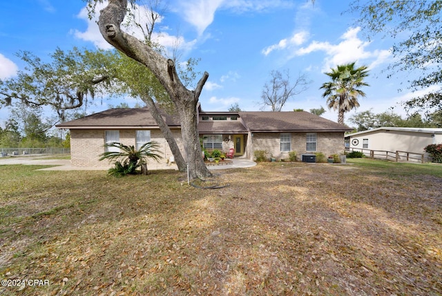 ranch-style home featuring central AC unit and a front yard