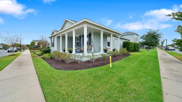 view of side of home with covered porch and a yard