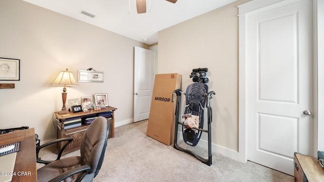 carpeted home office featuring ceiling fan