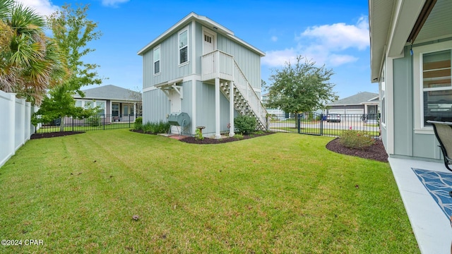 view of yard with a fenced backyard and stairs