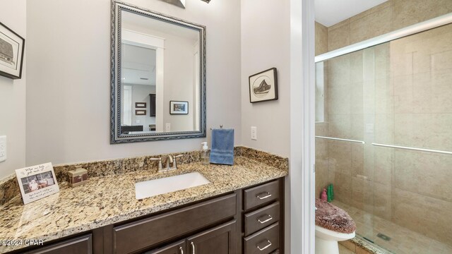 bathroom featuring walk in shower, vanity, and toilet