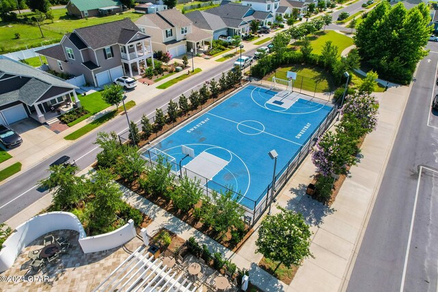 view of sport court featuring community basketball court, fence, and a residential view