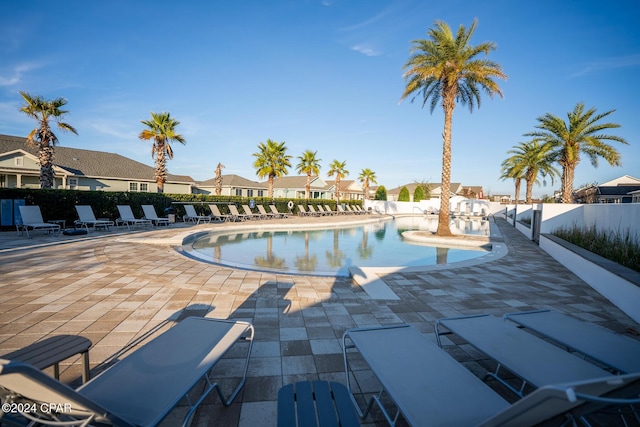 pool featuring a patio area, fence, and a residential view