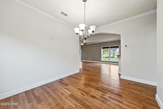 unfurnished dining area with wood-type flooring, ceiling fan with notable chandelier, and ornamental molding