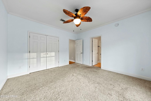 unfurnished bedroom featuring carpet floors, a closet, ceiling fan, and ornamental molding