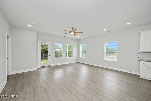 unfurnished living room with wood-type flooring and ceiling fan