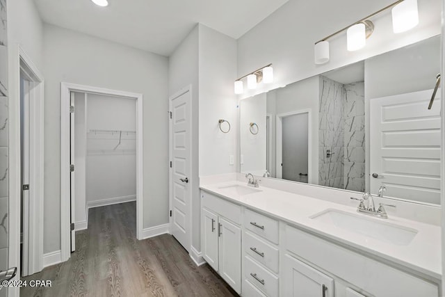 bathroom featuring vanity, hardwood / wood-style floors, and a tile shower