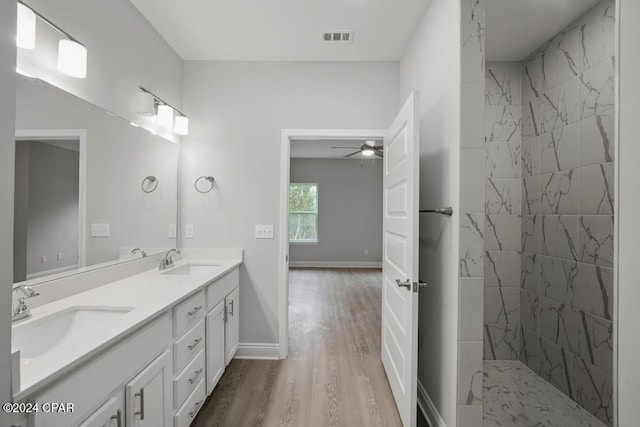 bathroom with vanity, hardwood / wood-style floors, ceiling fan, and a tile shower