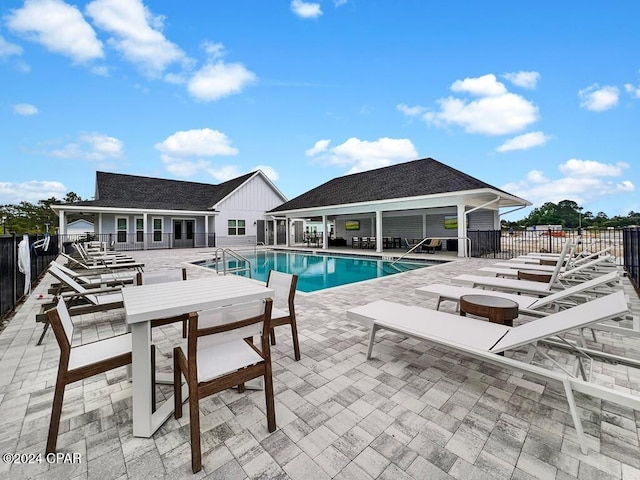 view of swimming pool with an outdoor structure and a patio area