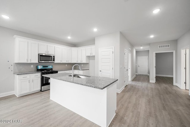 kitchen featuring light stone counters, stainless steel appliances, and white cabinets