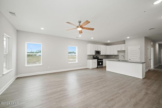 unfurnished living room with dark hardwood / wood-style flooring, sink, and ceiling fan