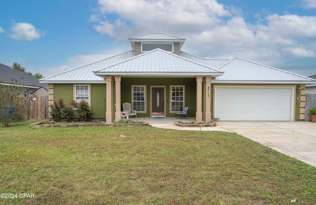 view of front of house with a garage, covered porch, and a front yard