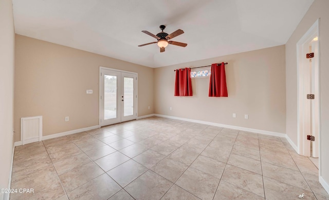 tiled empty room with ceiling fan and french doors