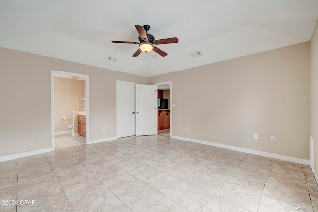 unfurnished bedroom featuring ensuite bathroom and ceiling fan