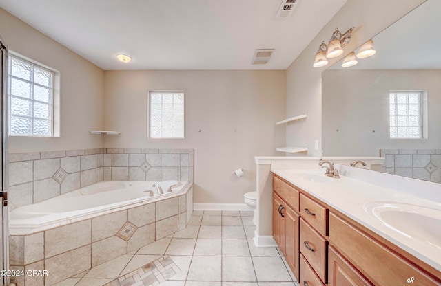 bathroom with tile patterned floors, vanity, toilet, and tiled tub