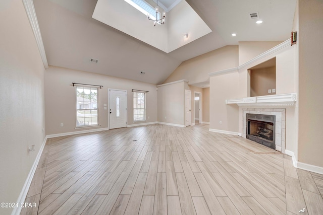 unfurnished living room with a tiled fireplace, light hardwood / wood-style flooring, and high vaulted ceiling