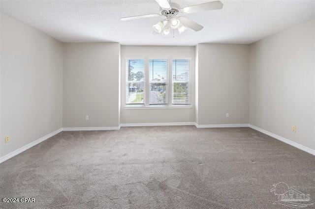 carpeted spare room featuring ceiling fan