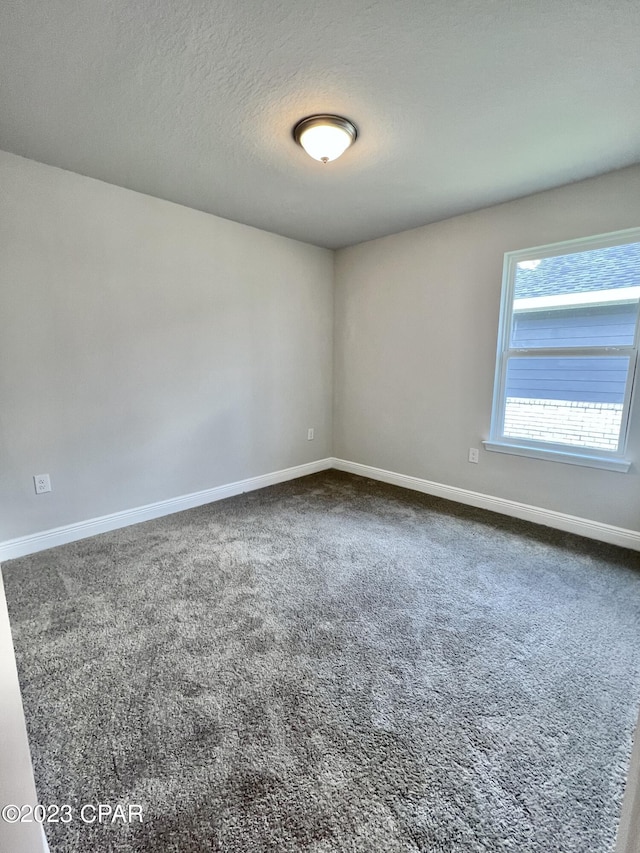 1202 Primrose Ln, Panama City, FL 32404 - unfurnished room with baseboards, dark colored carpet, and a textured ceiling