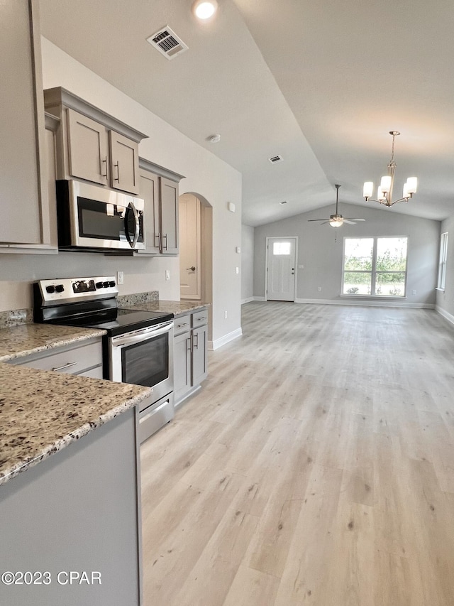 1202 Primrose Ln, Panama City, FL 32404 - kitchen with stainless steel appliances, lofted ceiling, gray cabinetry, open floor plan, and arched walkways