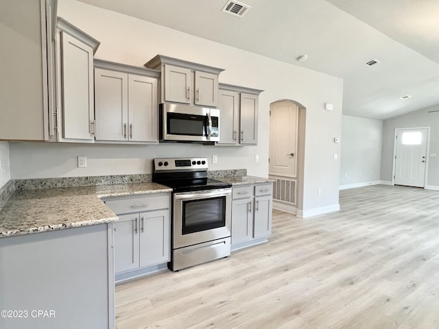 1202 Primrose Ln, Panama City, FL 32404 - kitchen featuring appliances with stainless steel finishes, gray cabinets, light wood-style floors, arched walkways, and baseboards