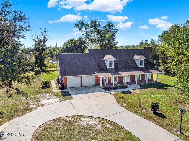 view of front of property with a porch, a garage, and a front yard