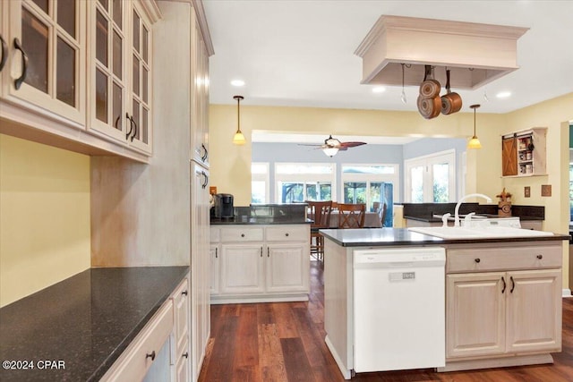 kitchen featuring dark wood finished floors, dishwasher, dark countertops, glass insert cabinets, and a sink