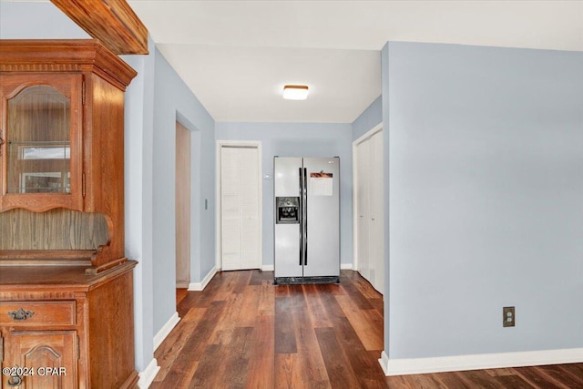 hallway featuring baseboards and dark wood-style flooring