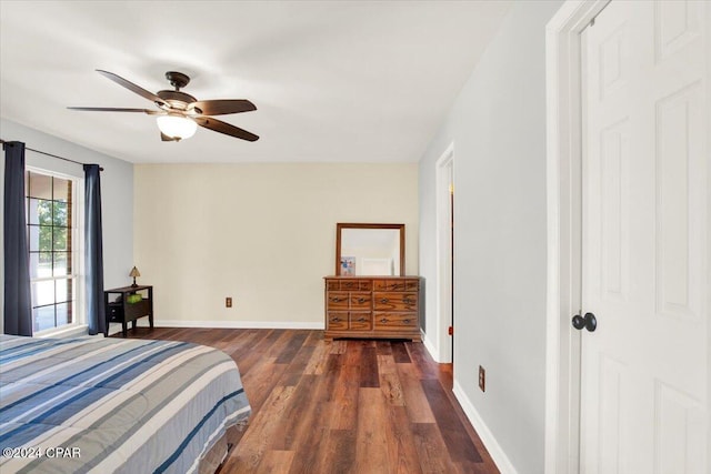 bedroom with a ceiling fan, baseboards, and wood finished floors