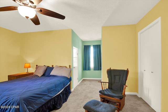 bedroom featuring ceiling fan, a textured ceiling, baseboards, and carpet flooring