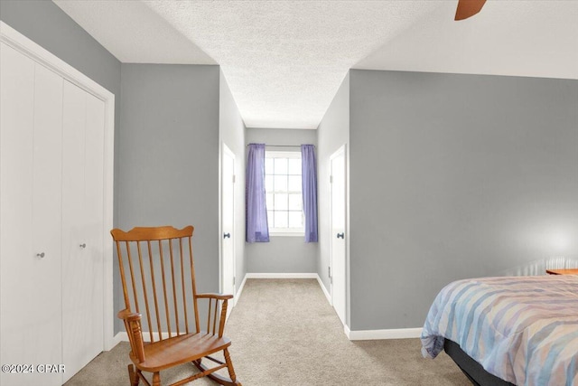 carpeted bedroom featuring a ceiling fan, a closet, a textured ceiling, and baseboards