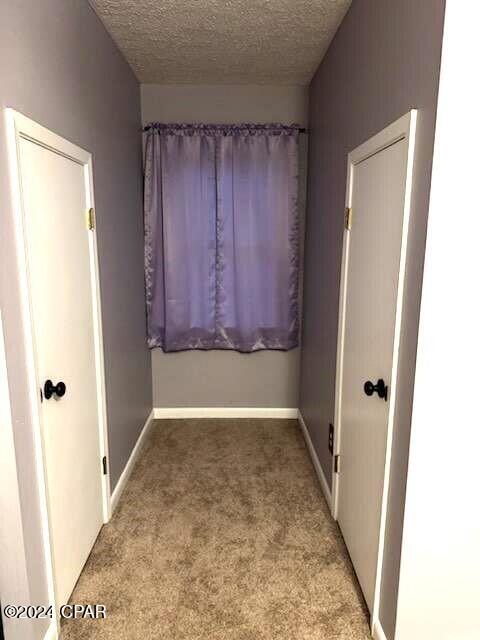 interior space with a textured ceiling and baseboards