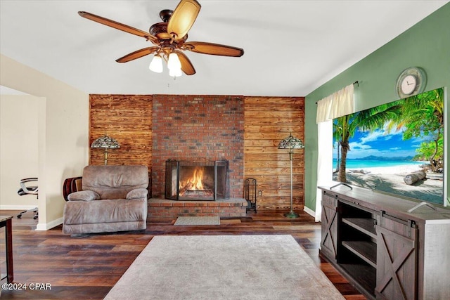 living room with ceiling fan, a fireplace, baseboards, and wood finished floors