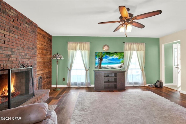 living area with ceiling fan, a fireplace, baseboards, and wood finished floors