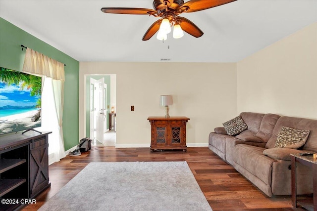 living area with a ceiling fan, visible vents, baseboards, and wood finished floors