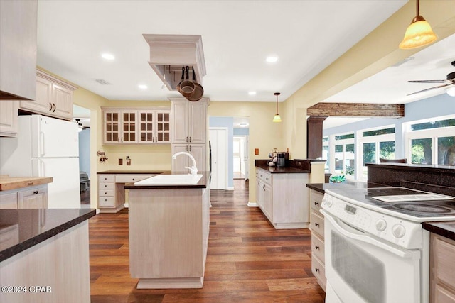 kitchen featuring dark wood-style floors, white appliances, an island with sink, and a ceiling fan