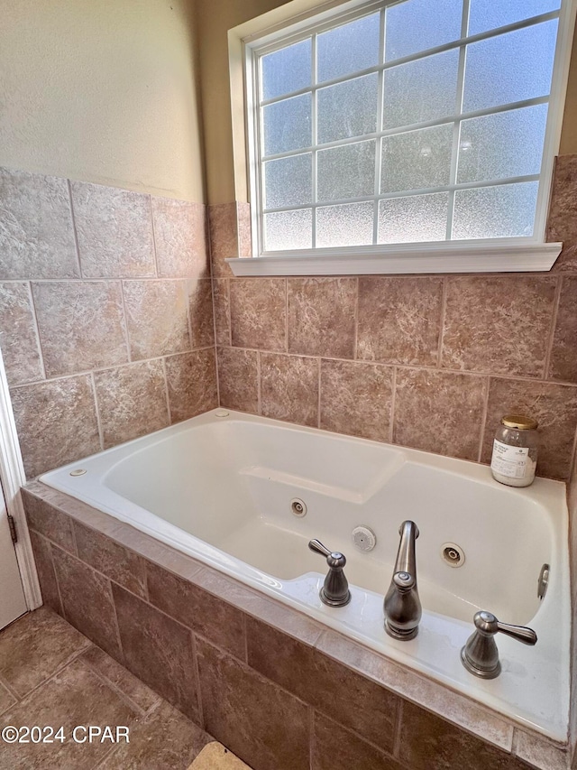 bathroom featuring tile patterned flooring and a relaxing tiled tub