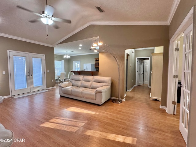 living room with french doors, lofted ceiling, light hardwood / wood-style floors, and ornamental molding