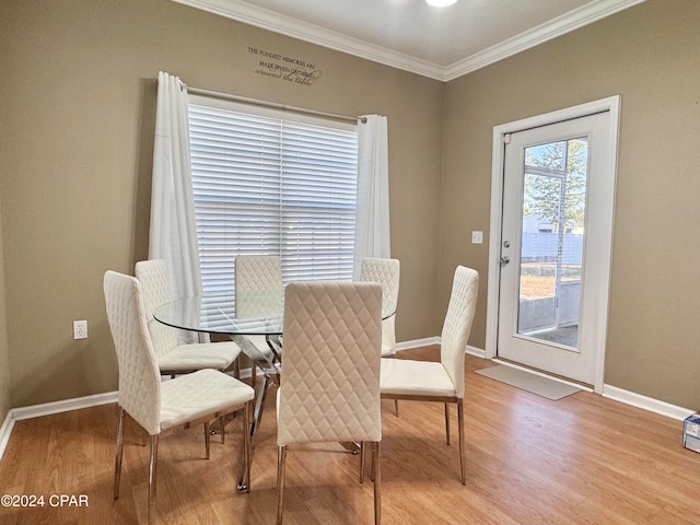 dining room with light hardwood / wood-style floors and crown molding