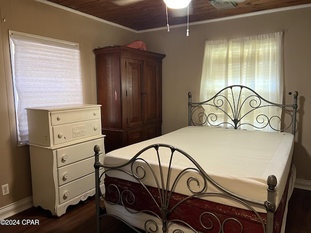 bedroom featuring dark hardwood / wood-style floors, multiple windows, and crown molding