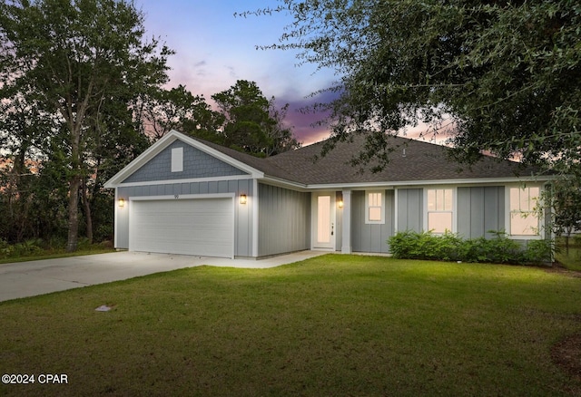 ranch-style house featuring a yard and a garage