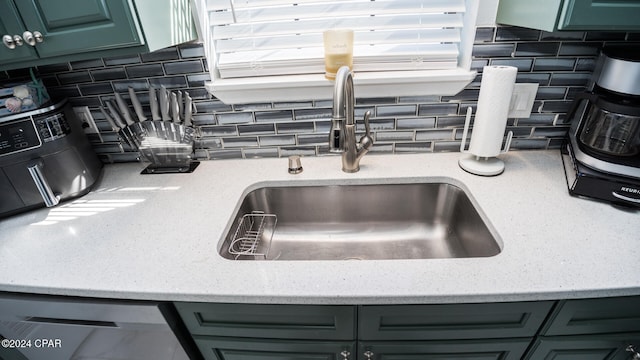 room details featuring tasteful backsplash, sink, and green cabinetry