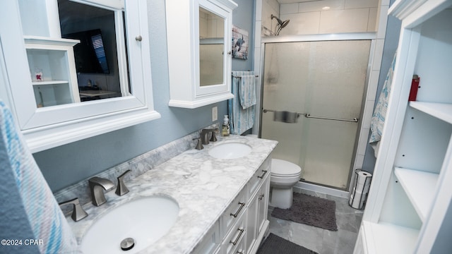 bathroom featuring vanity, toilet, and a shower with shower door