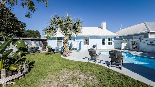 rear view of house featuring a fenced in pool, a yard, and a patio