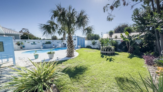 view of yard with a fenced in pool and a storage shed