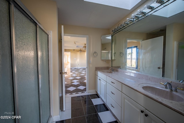 bathroom featuring a skylight, vanity, and a shower with shower door