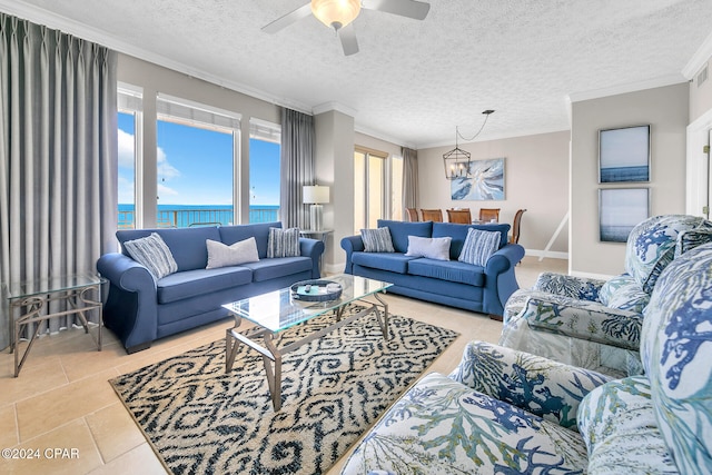 living room featuring ceiling fan with notable chandelier, a water view, crown molding, a textured ceiling, and light tile patterned flooring