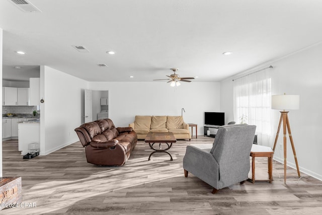 living room with hardwood / wood-style flooring and ceiling fan