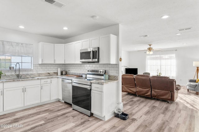 kitchen featuring white cabinets, sink, light wood-type flooring, and stainless steel appliances